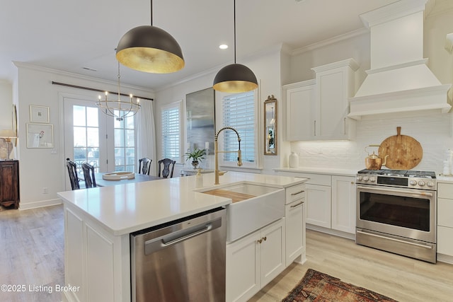 kitchen featuring white cabinetry, a center island with sink, custom range hood, and appliances with stainless steel finishes