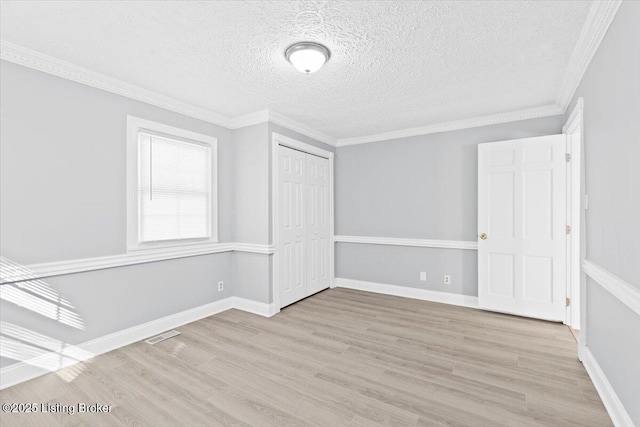 interior space with crown molding, light hardwood / wood-style flooring, and a textured ceiling