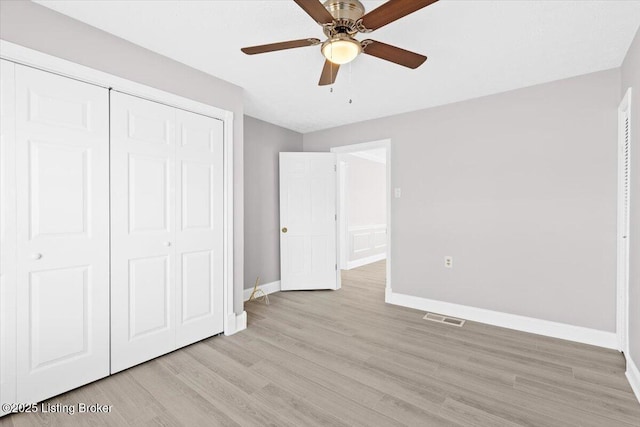 unfurnished bedroom featuring ceiling fan, a closet, and light hardwood / wood-style flooring