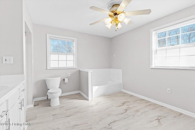 bathroom with ceiling fan, vanity, toilet, and a bathing tub