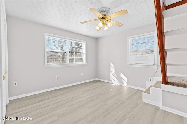 unfurnished room featuring ceiling fan, a textured ceiling, and light wood-type flooring