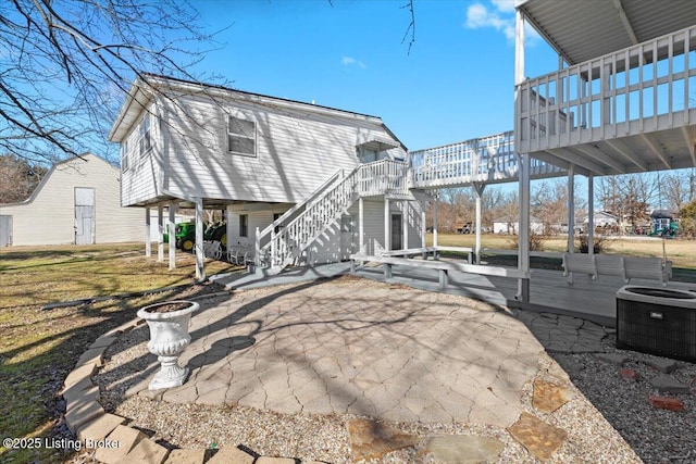 back of property featuring central AC, a deck, and a patio area