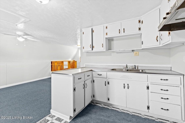 kitchen featuring sink, vaulted ceiling, a textured ceiling, dark carpet, and white cabinets