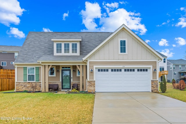 craftsman inspired home with a garage and a front lawn