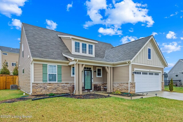 craftsman-style home with a garage, a front lawn, and central air condition unit