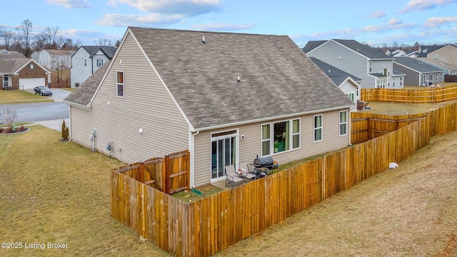 rear view of property featuring a lawn