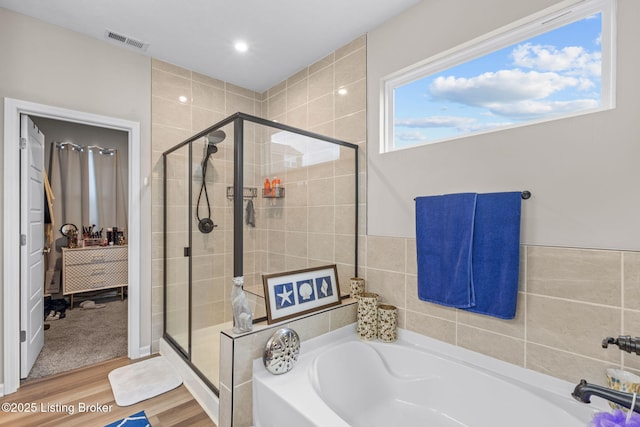 bathroom featuring shower with separate bathtub and wood-type flooring