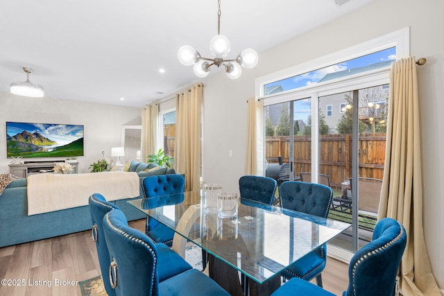 dining area featuring hardwood / wood-style floors and an inviting chandelier