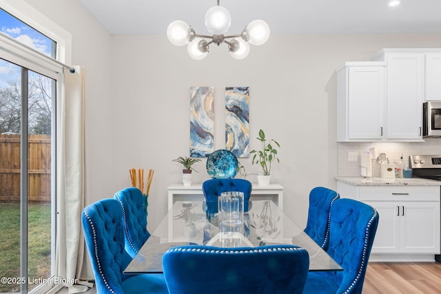 dining area featuring an inviting chandelier and light wood-type flooring