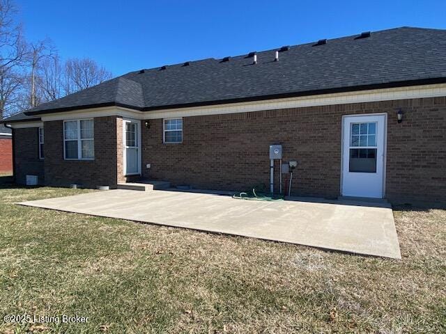 back of house with a patio and a lawn