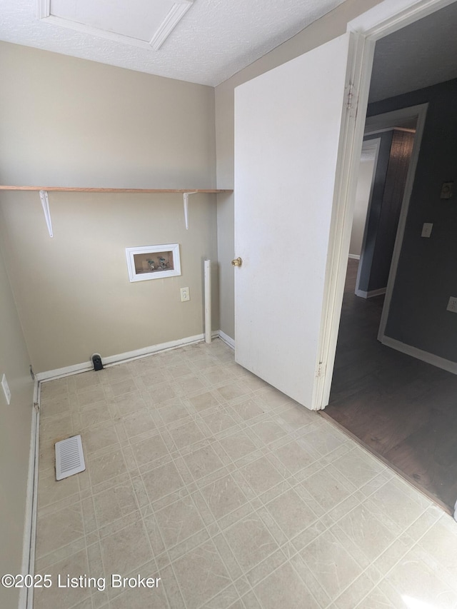 laundry room with hookup for a washing machine and a textured ceiling