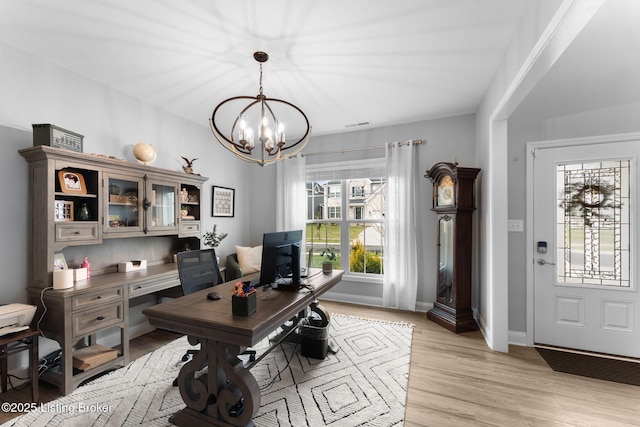 office space with a chandelier and light wood-type flooring