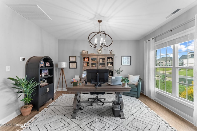 office with a notable chandelier and light wood-type flooring