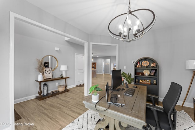 home office with a chandelier and light wood-type flooring