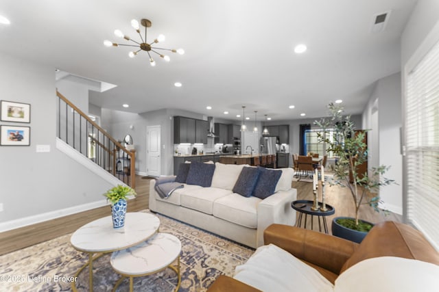 living room featuring sink, hardwood / wood-style flooring, and a chandelier