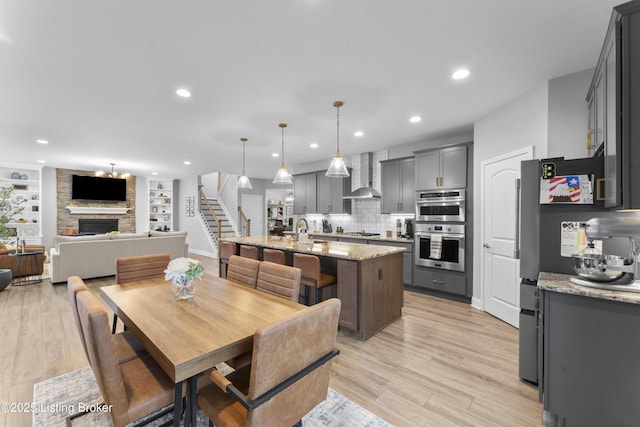 dining room with a fireplace, sink, and light wood-type flooring