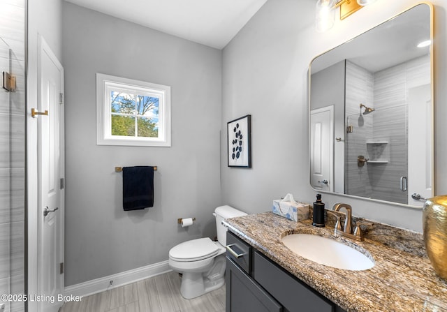 bathroom featuring vanity, toilet, and a shower with shower door