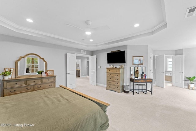 carpeted bedroom featuring ceiling fan, ornamental molding, a tray ceiling, and ensuite bathroom