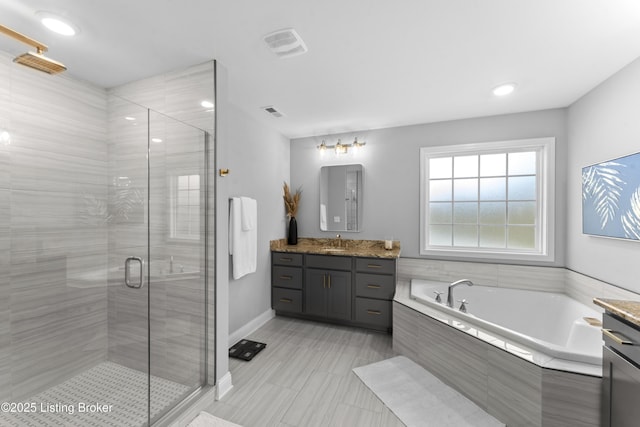 bathroom with vanity and shower with separate bathtub