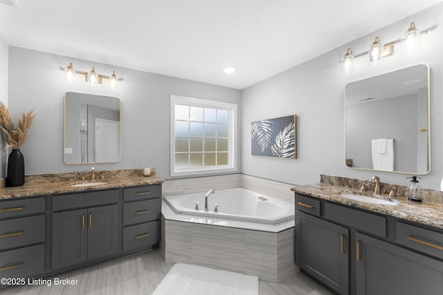 bathroom featuring vanity and a relaxing tiled tub