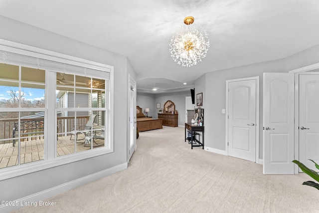 corridor featuring light carpet and a notable chandelier