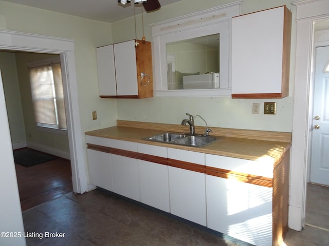 kitchen with ceiling fan, a healthy amount of sunlight, sink, and white cabinets