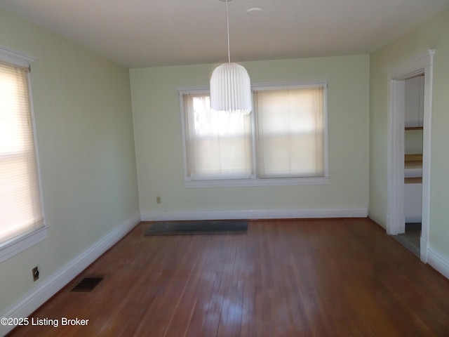 unfurnished dining area with dark wood-type flooring