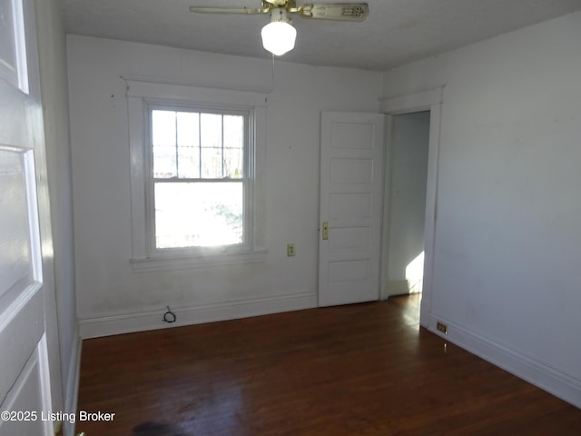 empty room with dark hardwood / wood-style floors and ceiling fan