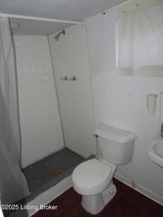 bathroom featuring curtained shower and toilet