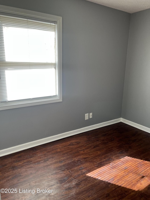 unfurnished room with dark hardwood / wood-style flooring