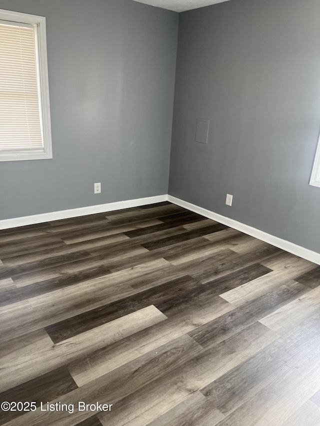 unfurnished room with dark wood-type flooring