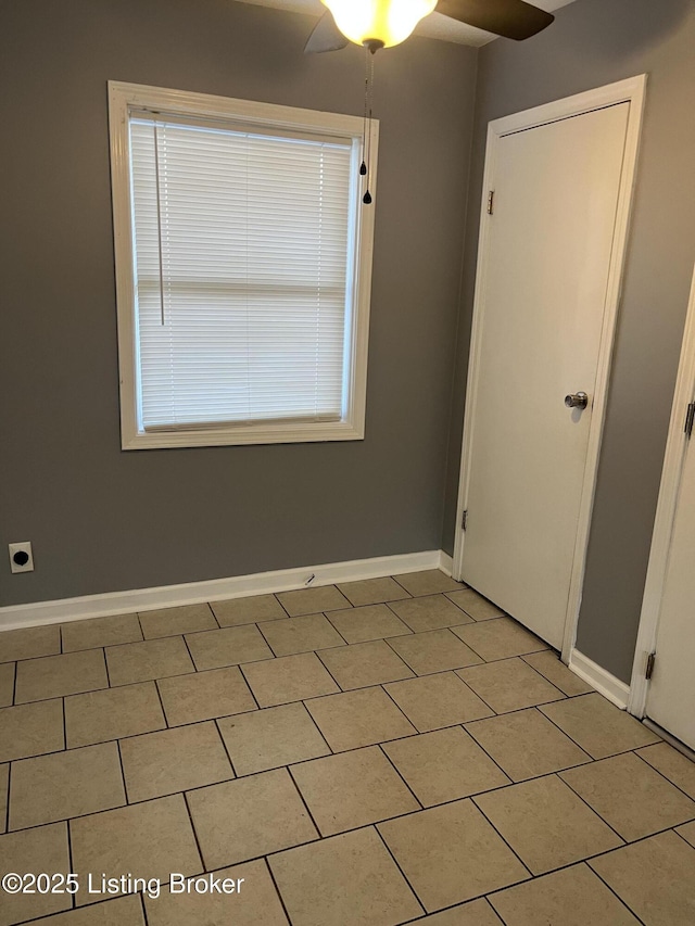 empty room featuring ceiling fan and light tile patterned flooring