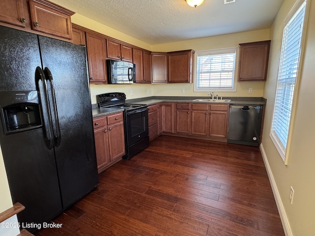 kitchen featuring sink, dark wood-type flooring, a textured ceiling, and black appliances