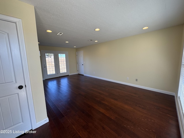 empty room featuring dark hardwood / wood-style flooring and a textured ceiling