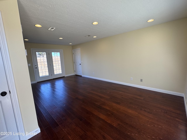 unfurnished room featuring dark hardwood / wood-style floors and a textured ceiling