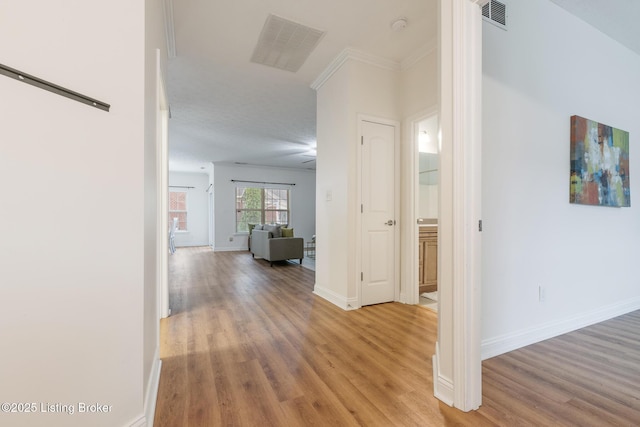 hallway with hardwood / wood-style floors and ornamental molding