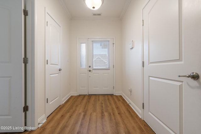 doorway to outside featuring crown molding and light hardwood / wood-style floors