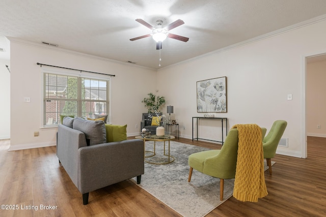 living room featuring wood-type flooring, ornamental molding, and ceiling fan