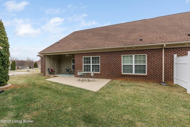 back of house featuring a lawn, ceiling fan, and a patio area