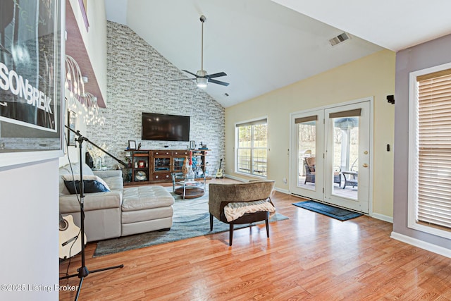 living room featuring ceiling fan, hardwood / wood-style floors, and high vaulted ceiling