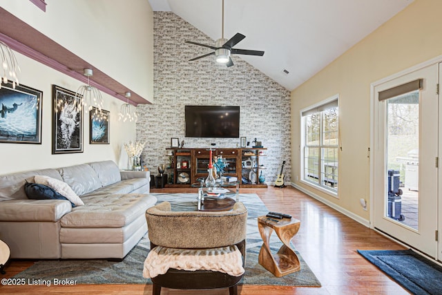 living room with ceiling fan, wood-type flooring, and high vaulted ceiling