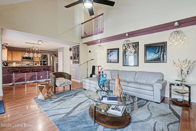 living room with ceiling fan and light wood-type flooring