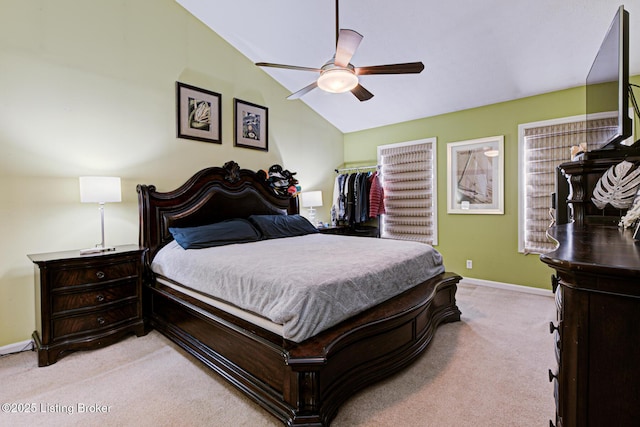 bedroom with light carpet, vaulted ceiling, a closet, and ceiling fan