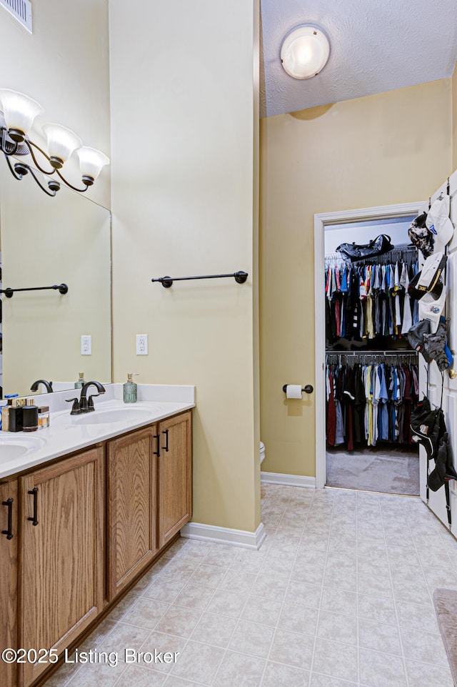 bathroom with tile patterned floors, vanity, toilet, and a textured ceiling