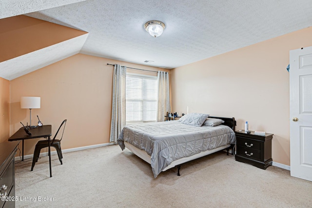 bedroom with lofted ceiling, light colored carpet, and a textured ceiling