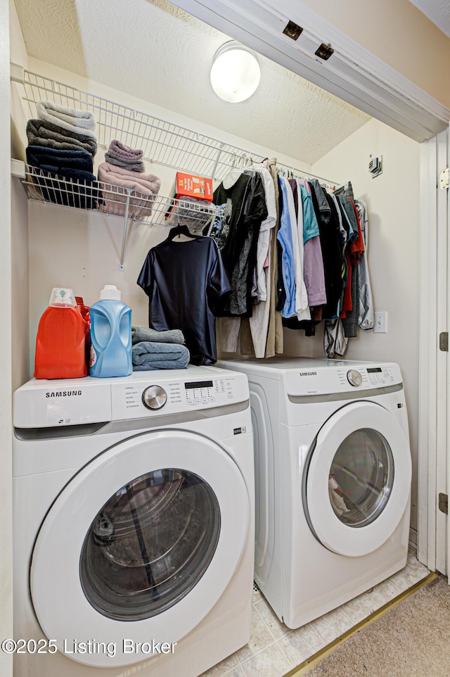 laundry area featuring washer and clothes dryer and a textured ceiling