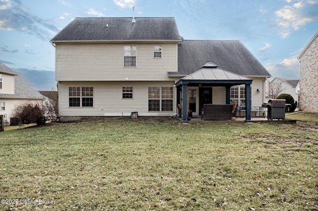 back of property with a gazebo, central AC unit, a patio area, and a lawn