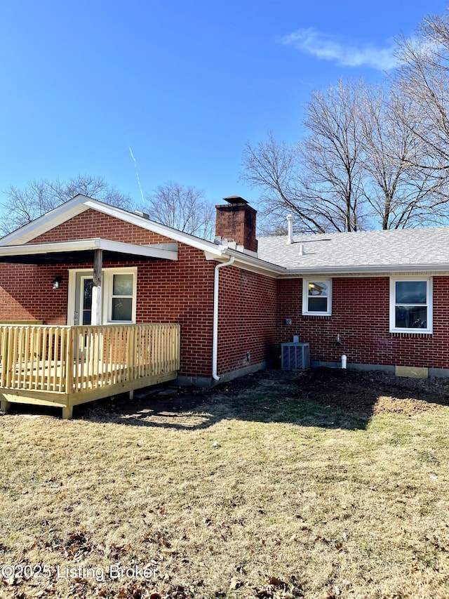 rear view of property featuring a wooden deck, central AC unit, and a lawn