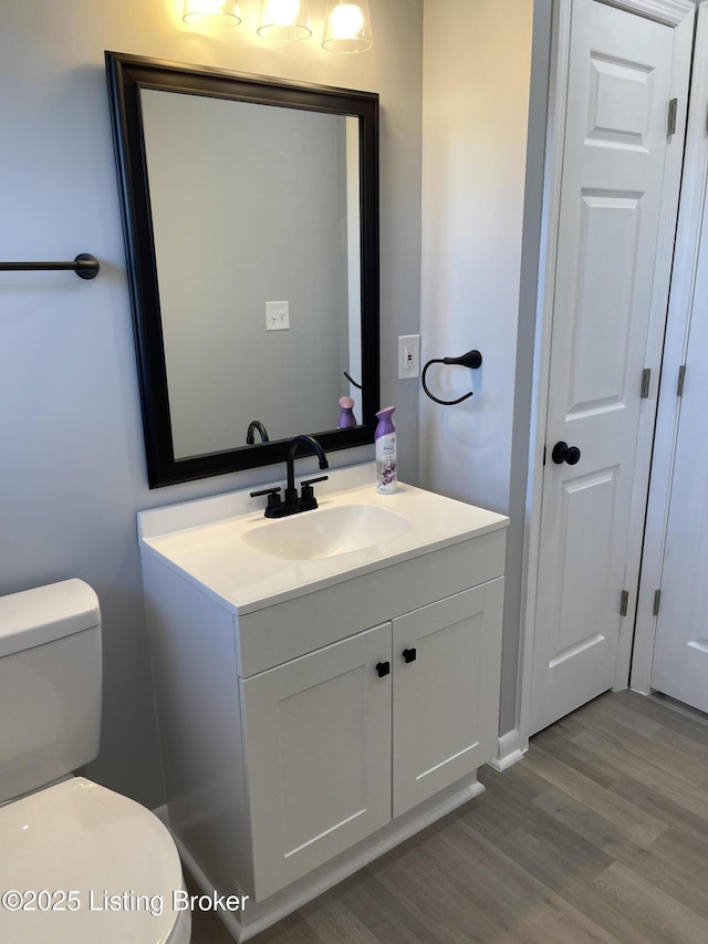 bathroom featuring hardwood / wood-style flooring, vanity, and toilet