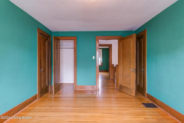 unfurnished bedroom with light hardwood / wood-style flooring and a closet